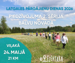 Attēlā redzams pārgājiena pasākuma plakāts — cilvēku grupa dodas pārgājienā pa ziedošu pļavu saulainā dienā. Plakātā reklamētas “Latgales pārgājienu dienas 2026”, piedzīvojuma 2. sērija Balvu novadā. Norādīta norises vieta Viļaka, datums 24. maijs un distances garums — 21 km.