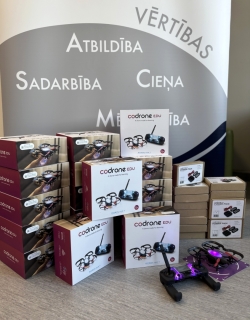 Attēlā redzams drons ar vadības pulti