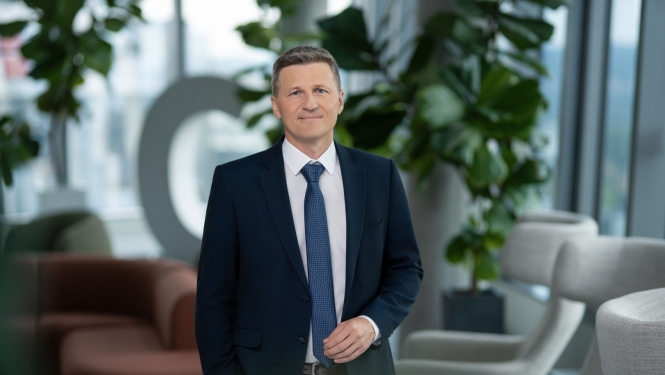 Attēlā redzams vīrietis, kurš skatās kamerā.