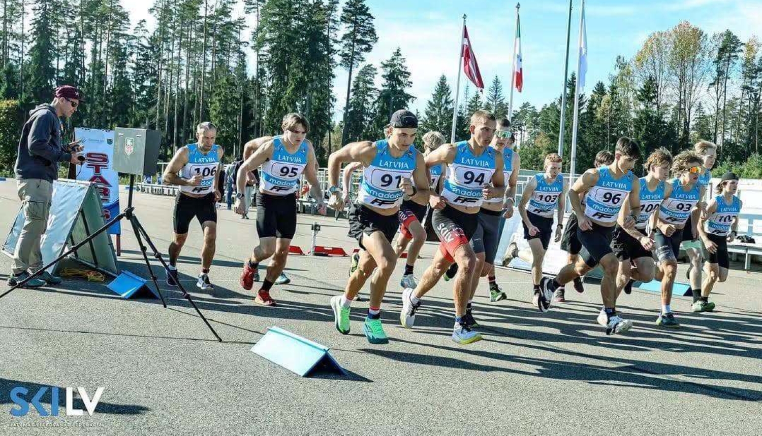 Attēlā redzami sportisti, kas izskrien no starta