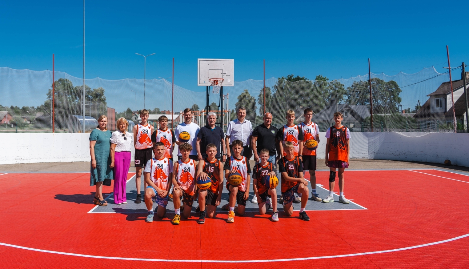 Basketbola komandas un oficiālo pārstāvju kopbilde uz 3×3 basketbola laukuma.