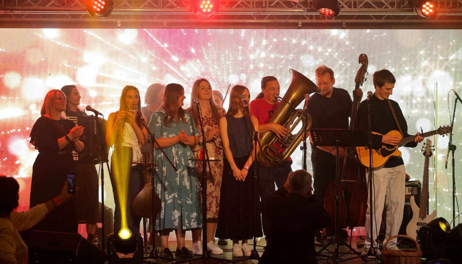 Attēlā redzama muzikantu grupa uz skatuves.