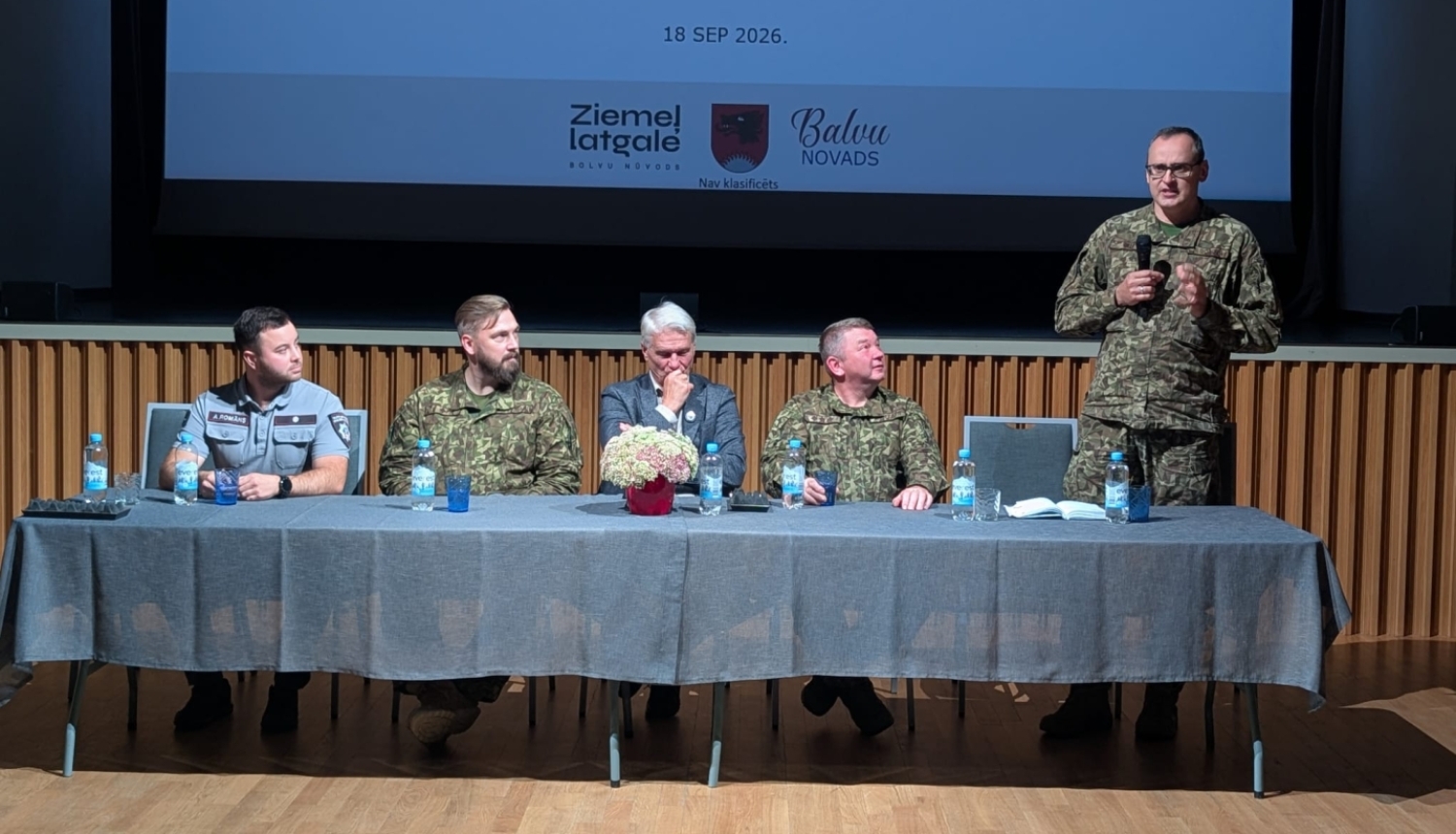 Attēlā redzamas amatpersonas - 5 vīriesi, kas sēž pie galda.