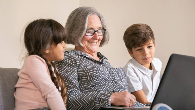 Gados vecāka sieviete kopā ar diviem bērniem apgūst datorprasmes