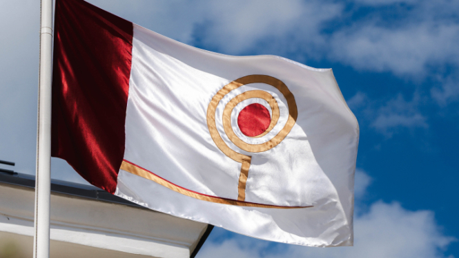 Attēlā redzams Starptautiskā klasiskās dramaturģijas amatierteātru festivāla "Ķiršu dārzs" karogs. Uz balto fona attēlots stilizēts ķirsis. 