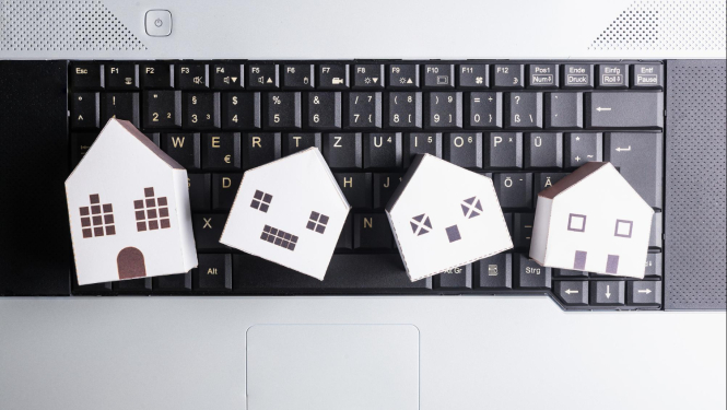 Uz datora kvaliatūras izkārtotas četras papīra mājiņas