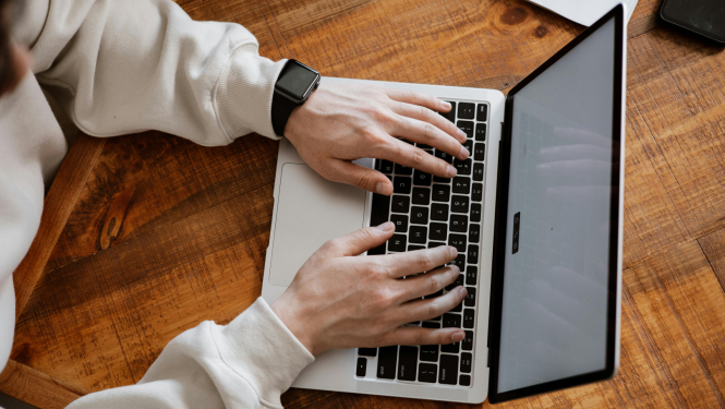 Cilvēks izmanto portatīvo datoru