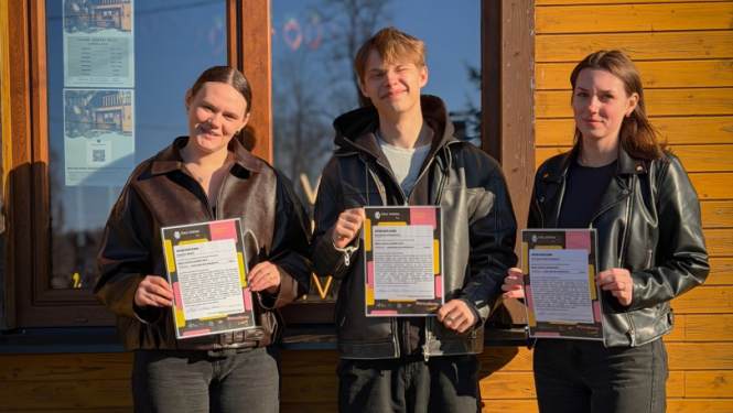 Trīs jaunieši ar sertifikātiem rokās stāv pie Viļakas jauniešu mājas