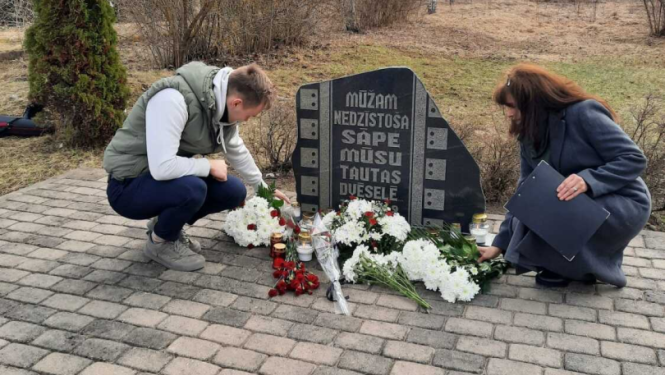 Noliek ziedus pie piemiņas akmens bijušajā Vecumu dzelzceļa stacijā