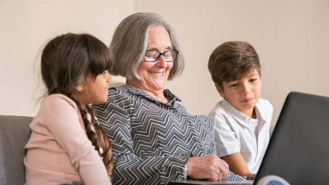 Gados vecāka sieviete kopā ar diviem bērniem apgūst datorprasmes