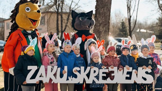 Pirmskolas vecuma bērni ar zaķa ausīm tur rokās nosaukumu ''Zaķu skrējiens''