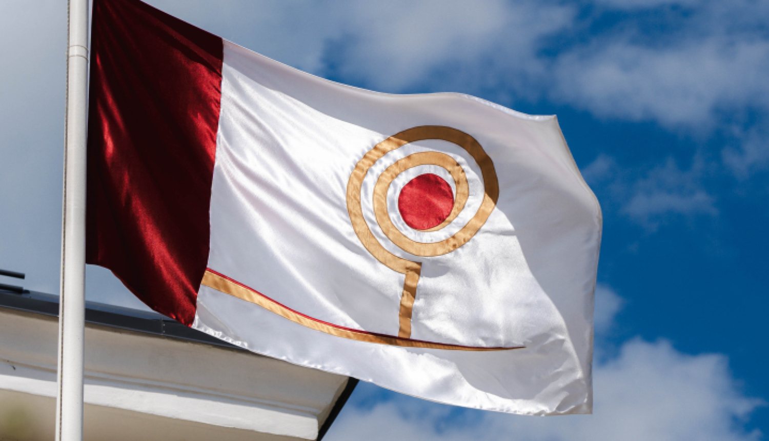 Attēlā redzams Starptautiskā klasiskās dramaturģijas amatierteātru festivāla "Ķiršu dārzs" karogs. Uz balto fona attēlots stilizēts ķirsis. 