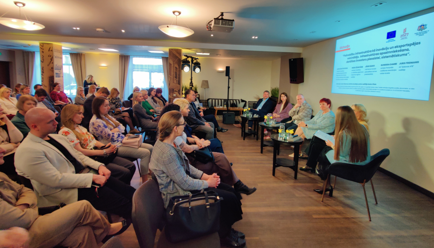 Telpa piepildīta ar cilvēkiem, kuri klātesošie semināra norisē