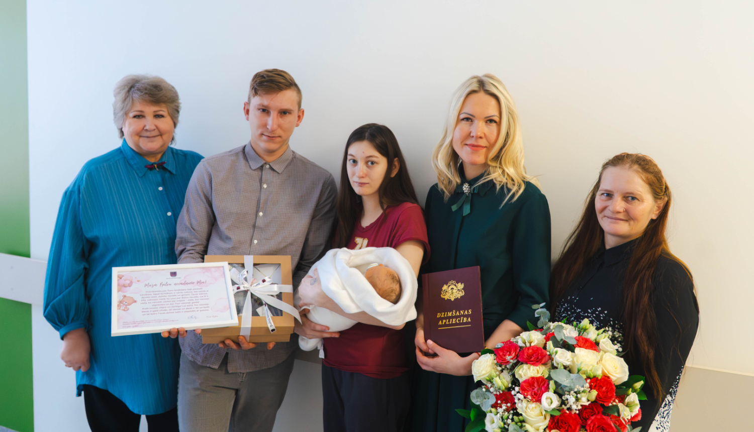 Balvu novada 2026. gada pirmais bērniņš meitenīte Mia kopā ar vecākiem un pārstāvjiem no Balvu novada pašvaldības