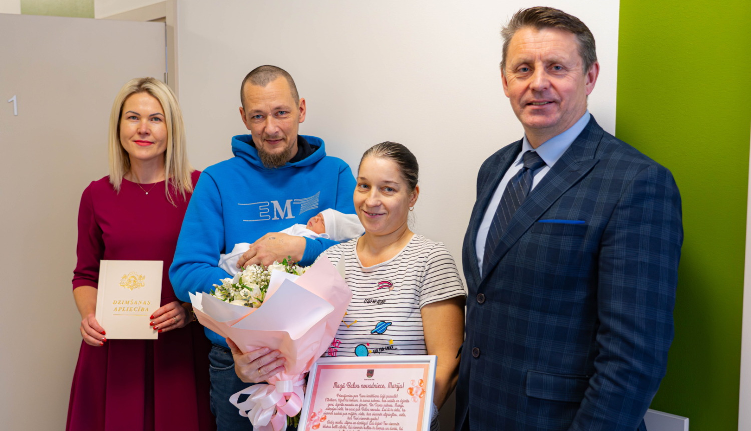 Balvu novada pašvaldības domes priekšsēdētājs un Dzimtsarakstu nodaļas vadītāja sveic pirmo novada dzimušo mazuli un viņa ģimeni