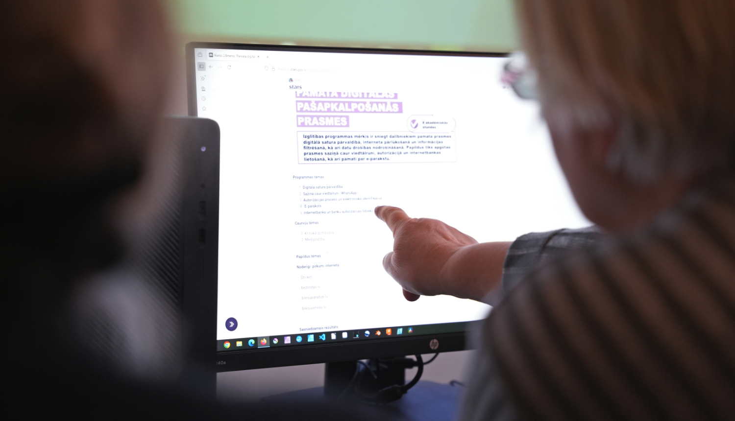 Sieviete norāda uz datora ekrānu 