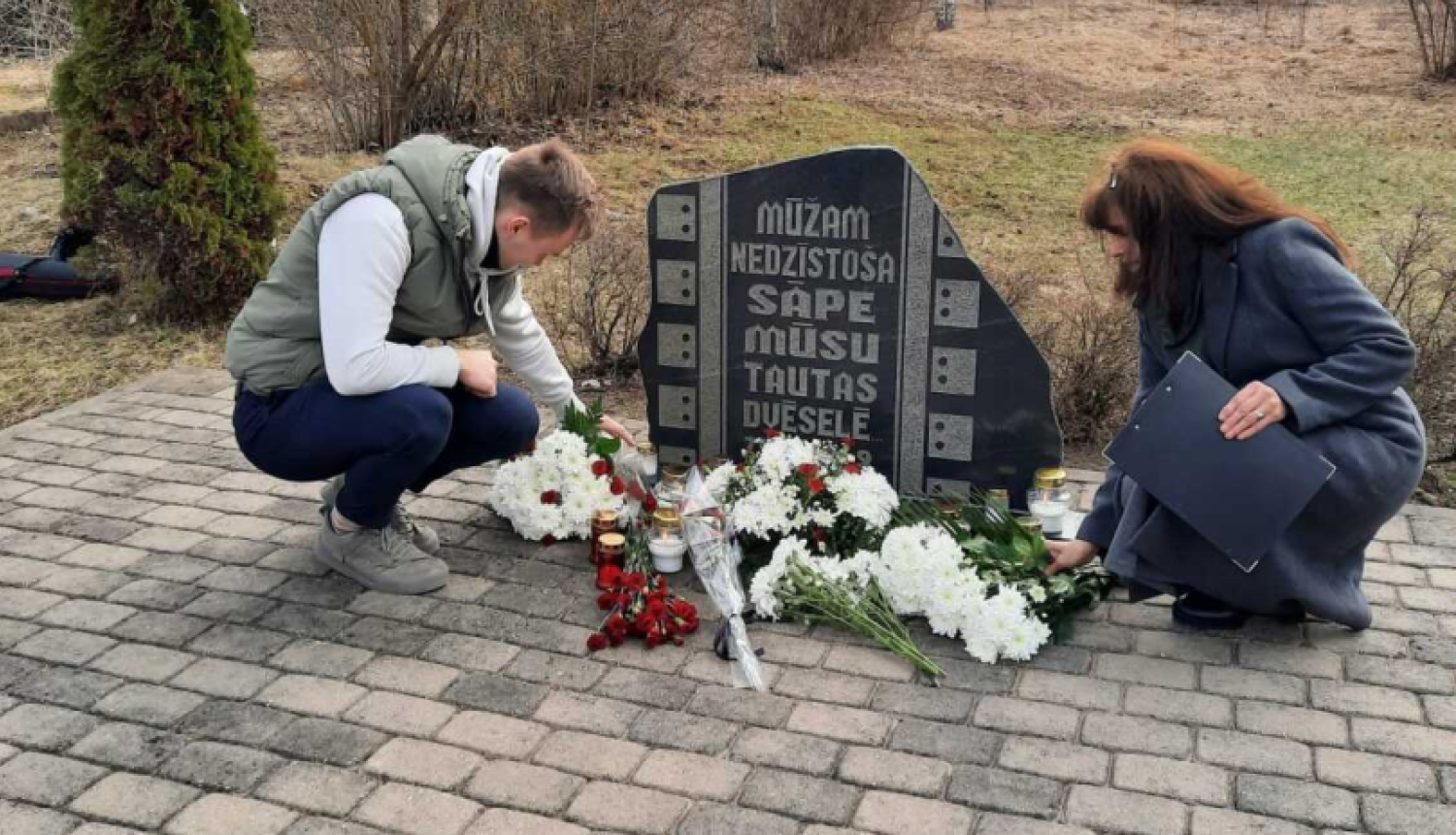 Noliek ziedus pie piemiņas akmens bijušajā Vecumu dzelzceļa stacijā