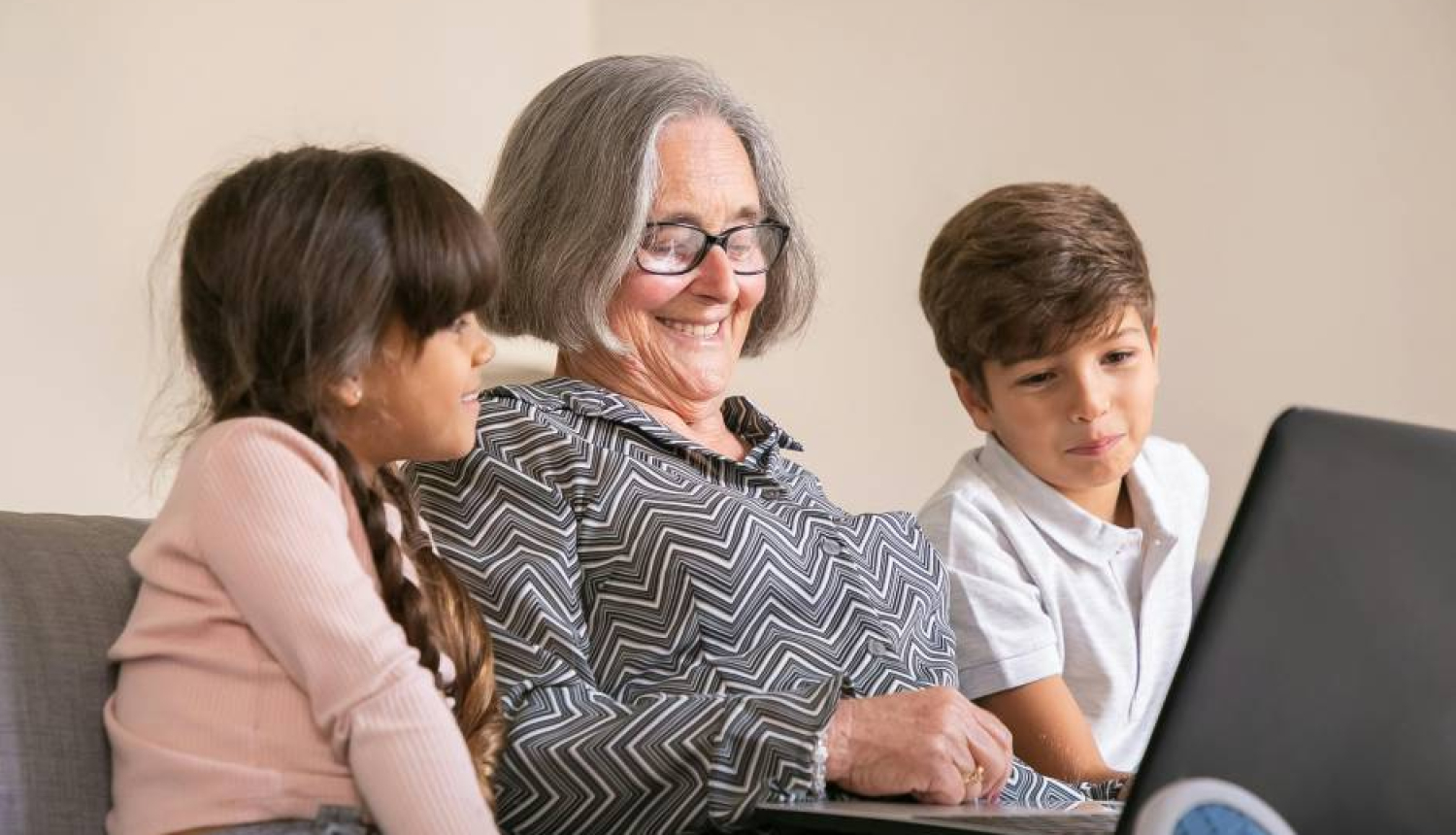 Gados vecāka sieviete kopā ar diviem bērniem apgūst datorprasmes