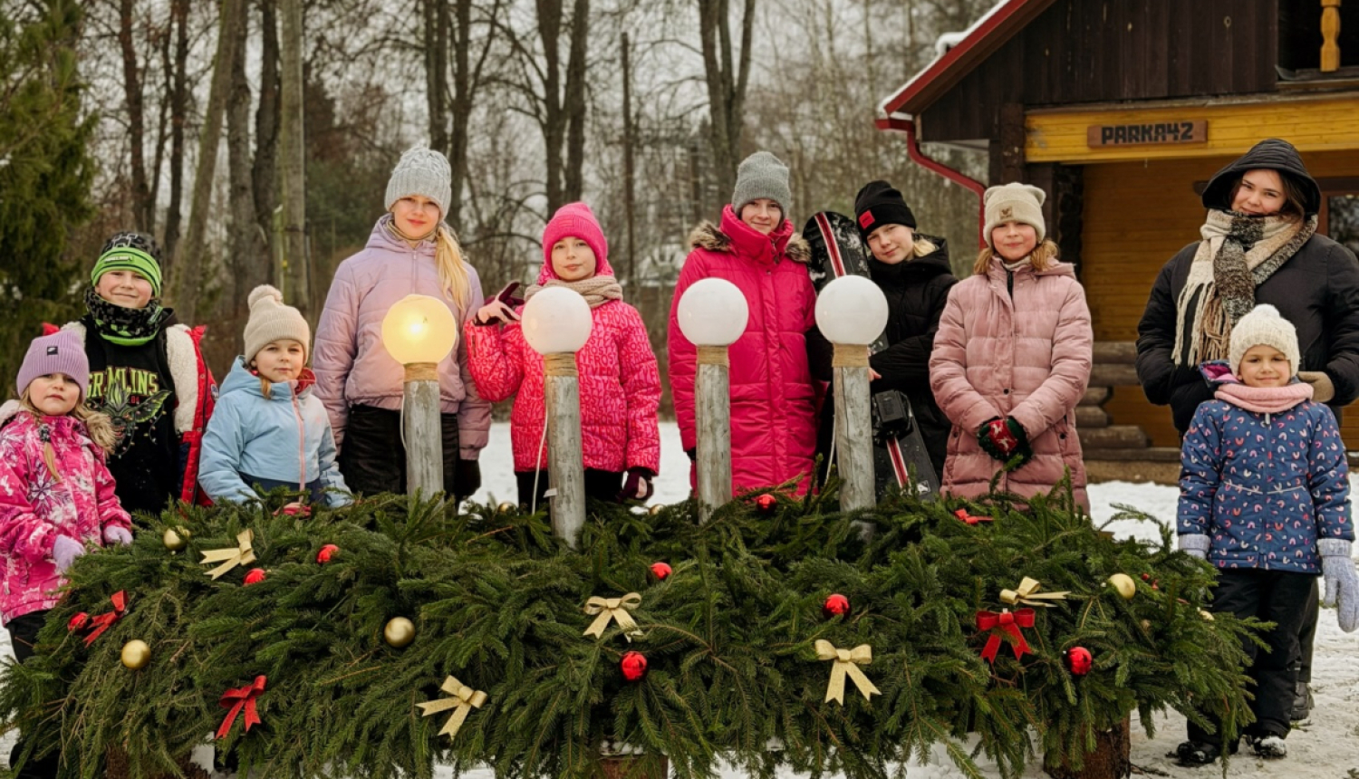 Diennakts nometnes ''Pidžāmu ballīte'' dalībnieki pie lielformāta Adventes vainaga